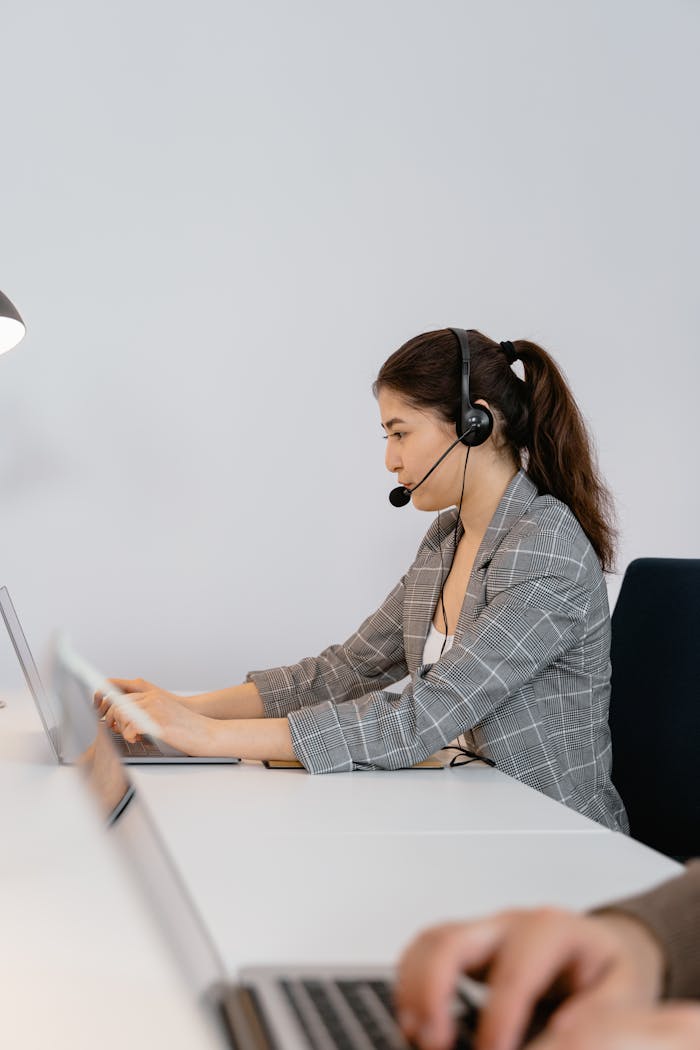 why-choose-us Focused call center agent wearing headphones providing customer support in a modern office.